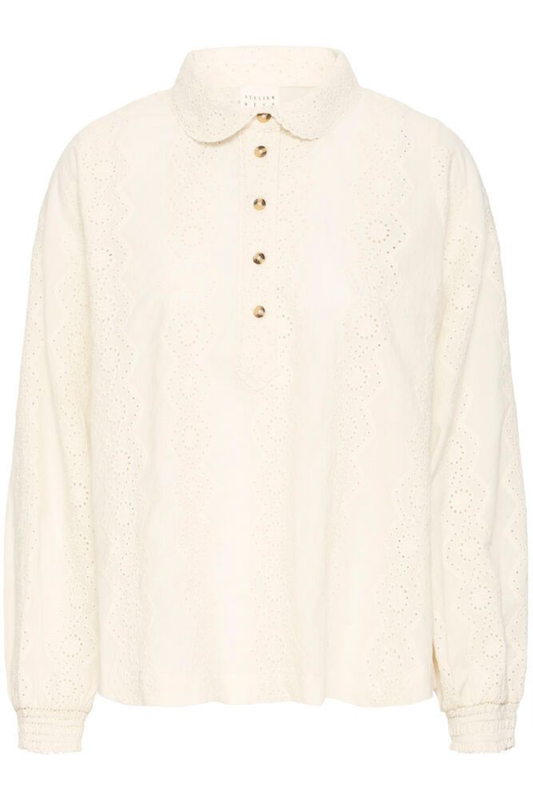 Relaxed cotton shirt by Atelier Rêve in a classic birch shade. Loose fit, long sleeves and easy everyday style. Shop at Dotique.