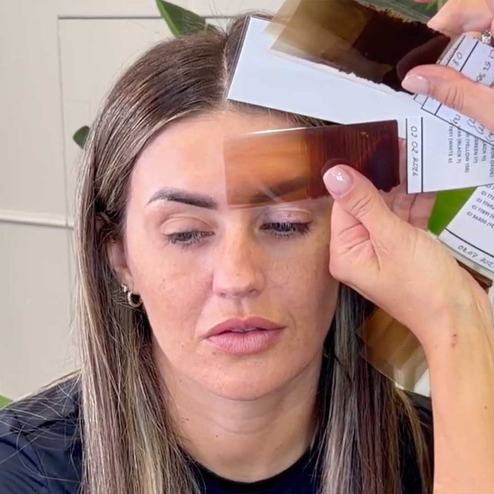 Close up of client face with eyebrow pigment swatch during color selection process