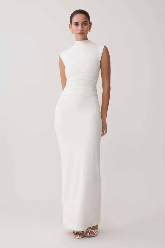 Woman wearing a white dress against a plain background