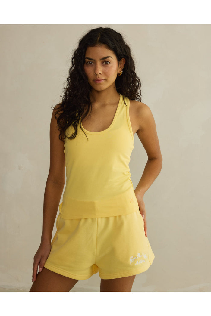 Model wearing Gym+Coffee Daily Cotton Shorts in Lemon Sorbet styled with matching tank top, shop Gym+Coffee at Dotique