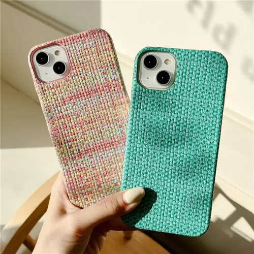 A hand holding a phone case with a green and pink pattern