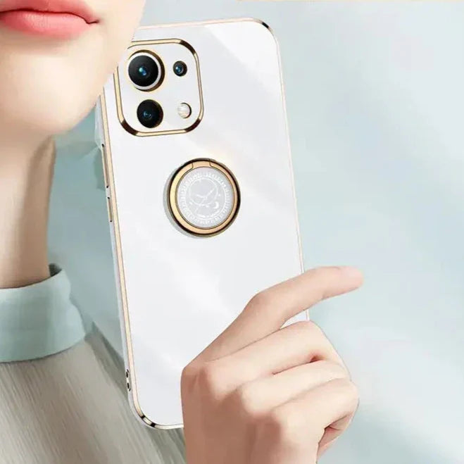 A woman holding a cell phone with a ring on it