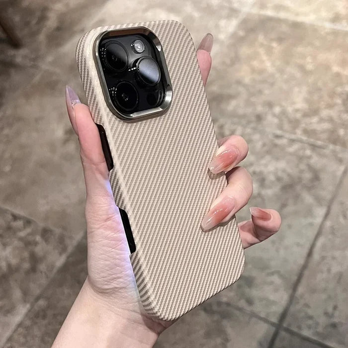 A hand holding a beige iPhone case with diagonal ribbed texture and a metallic camera frame.