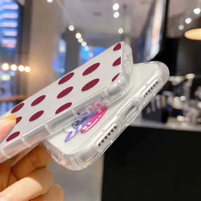 A woman holding a cell case with red polka dots
