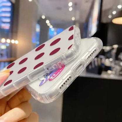 A woman holding a cell case with red polka dots